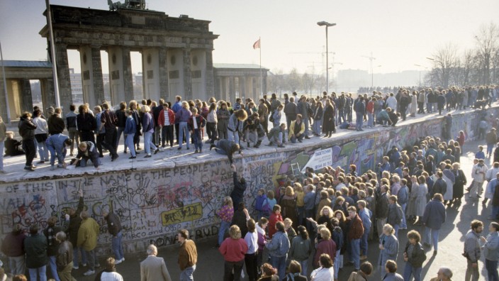 Fall der Berliner Mauer: Menschen aus Ost- und West-Berlin sind auf die Mauer am Brandenburger Tor geklettert. Berlin, Deutschland, Europa