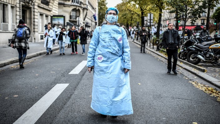 Wirtschaftspolitik: „Nicht anerkannt, nicht respektiert, unterbezahlt“, hat eine protestierende OP-Schwester in Paris auf ihren Kittel geschrieben.