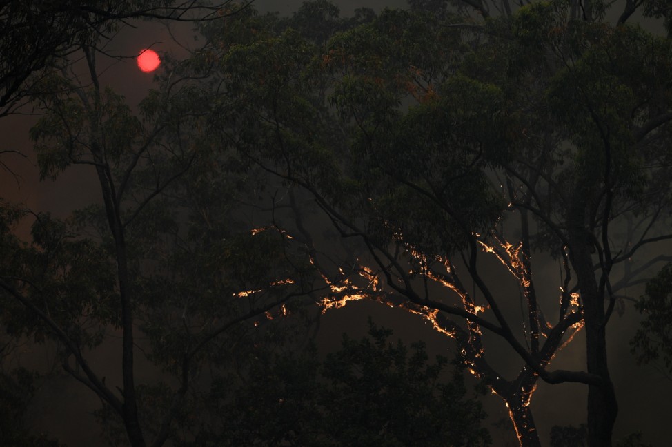 BUSHFIRES NSW, The sun is seen through thick smoke as fire burns close to property on Wheelbarrow Ridge Road at Colo Hei
