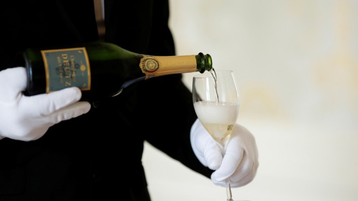FILE PHOTO: An employee serves a glass of Champagne during the traditional wine harvest at the Champagne house Deutz in Ay