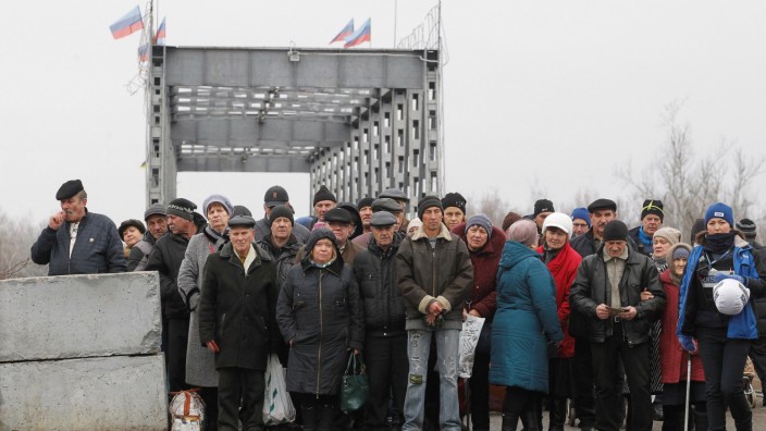 People cross a bridge under restoration in Stanytsia Luhanska