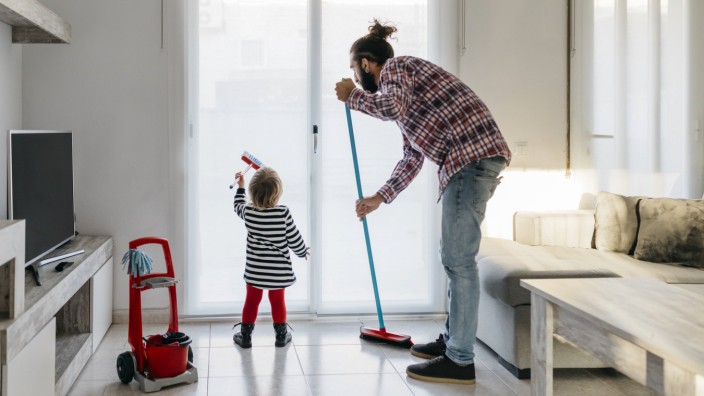 Father and little daughter cleaning the living room together model released Symbolfoto property rele