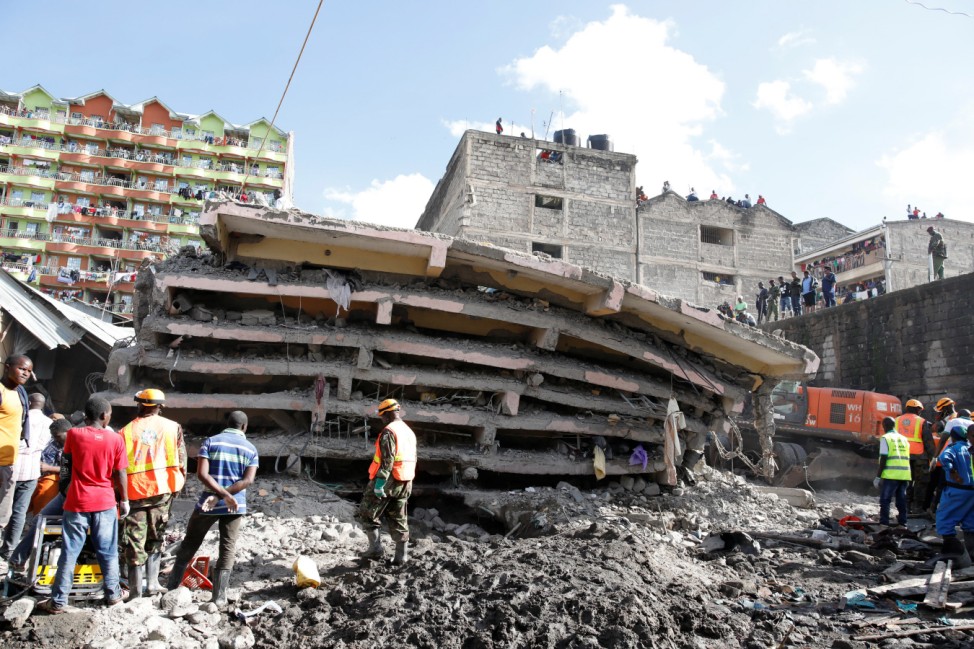 People watch as rescue teams search the scene where a building collapsed in Nairobi