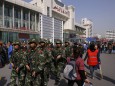 Armed police patrol near the exit of the South Railway Station, following Wednesday's bomb and knife attack, in Urumqi