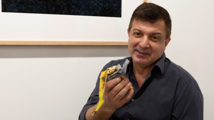 David Datuna shows the remains of the artwork 'Comedian' by the artist Maurizio Cattelan at Perrotin stand in Art Basel in Miami Beach