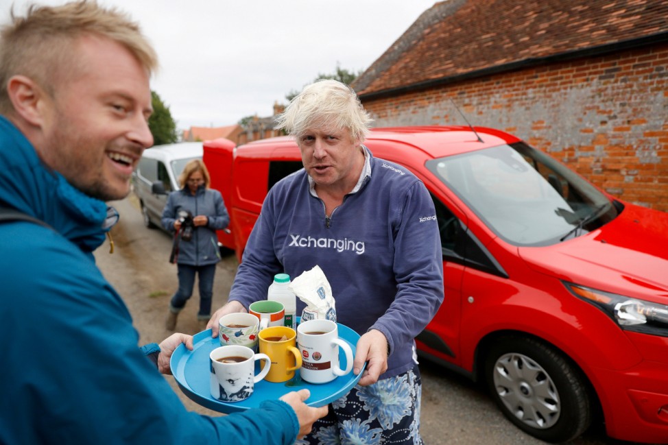 Britain's former Foreign Secretary Boris Johnson offers cups of tea to journalists outside his home near Thame in Oxfordshire