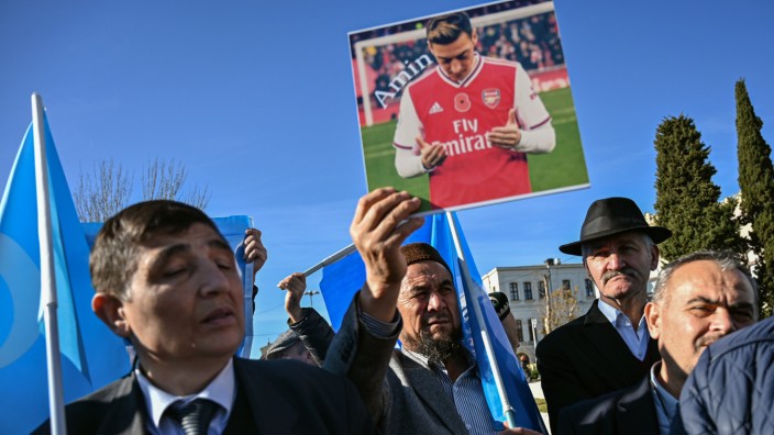 Uiguren halten ein Foto von Mesut Özil bei einer Demonstration in die Höhe