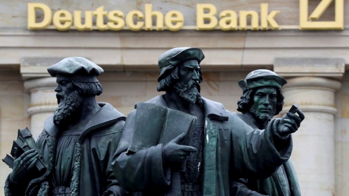 FILE PHOTO: A statue is pictured next to the logo of Germany's Deutsche Bank in Frankfurt