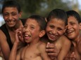 Egyptian boys laugh and smile after jump into the River Nile to cool off in Minya south of Cairo