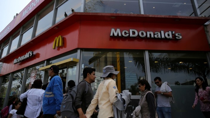 FILE PHOTO: People walk past McDonald's fast-food restaurant in Lima