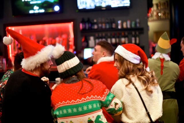 People in Santa Claus and elf outfits gather at the bar in The Field House after the 'Running of the Santas' annual pub crawl never materialized in Philadelphia
