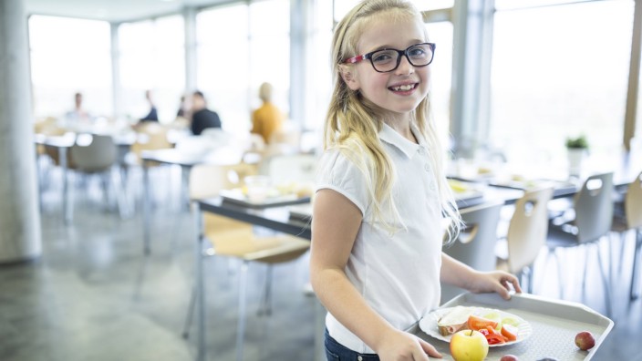 Portrait of smiling schoolgirl carrying tray in school canteen model released Symbolfoto property re