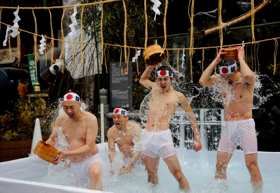 Men splash themselves with cold water during the annual cold water endurance ceremony, to purify their souls and wish for good fortune in the new year, at the Kanda Myojin shrine in Tokyo