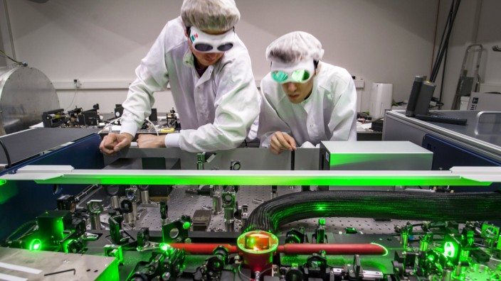 Doktoranden während ihrer Forschungsarbeit beim justieren ihres Versuchsaufbaus Laser Labor der Arb