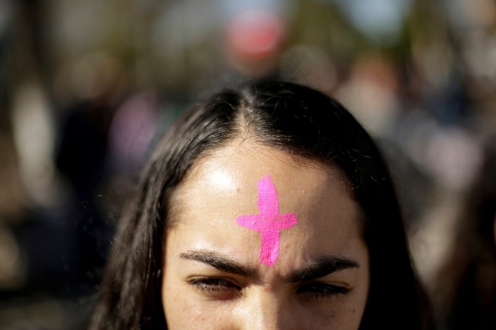 A woman with a  pink cross on his forehead takes part in a protest to demand justice for Isabel Cabanillas, an activist for women rights whose body was found last Saturday, in Ciudad Juarez