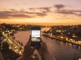 Woman s hands holding smartphone with a photo of panoramic view of Porto at sunset, Portugal model released Symbolfoto P