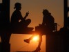 Sommerabend in München junge Frauen sitzen auf dem Geländer der Hackerbrücke und genießen den Sonne