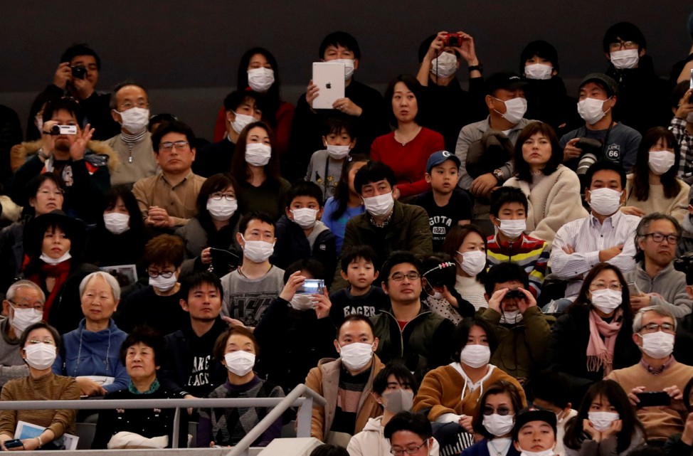 Visitors wearing surgical masks attend the opening ceremony of the Ariake Arena, which will host volleyball and wheelchair basketball competitions in Tokyo 2020 Olympic Games in Tokyo