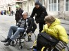 Paul Bickelbacher sitzt im Rollstuhl und testet gemeinsam mit einer weiteren Rollstuhlfahrerin, wie barrierefrei München ist. Die beiden versuchen, im Rollstuhl über einen Bordstein zu fahren.