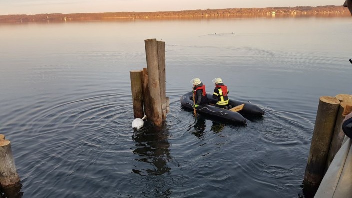 Starnberger See: Komplizierte Rettungsaktion: Feuerwehrleute rücken mit einem Boot an, um den Schwan zu befreien. Das Tier wäre beinahe ertrunken.