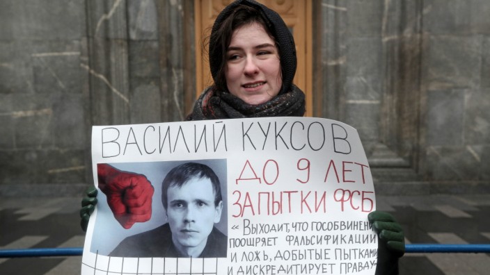 MOSCOW, RUSSIA - FEBRUARY 2, 2020: A young woman holds a sign showing a portrait of Vasily Kuksov with a message readin