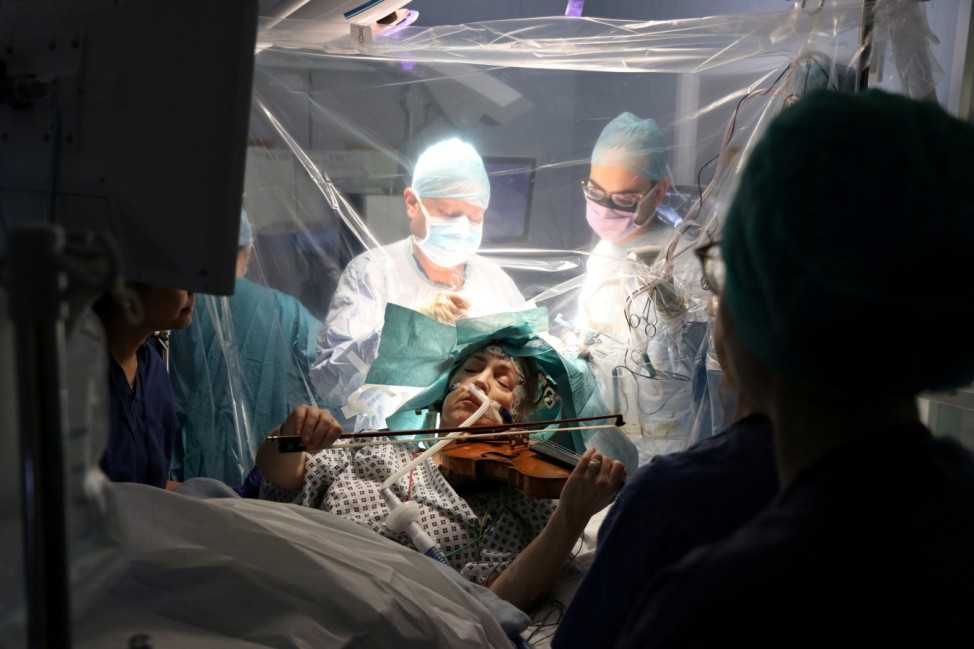 A patient Dagmar Turner, 53, plays violin while surgeons remove her brain tumour at King's College Hospital in London