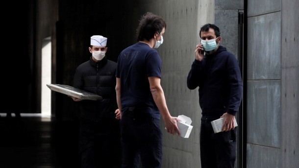 Workers wearing face masks are seen at the theatre where the Italian designer Giorgio Armani said his Milan Fashion Week show would take place in Milan