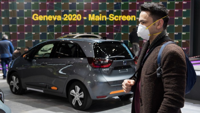 Autoindustrie: Mann mit Atemschutzmaske in Genf. Der Autosalon wurde wegen des Coronavirus abgesagt, ein neuer Termin steht schon fest – 2021.