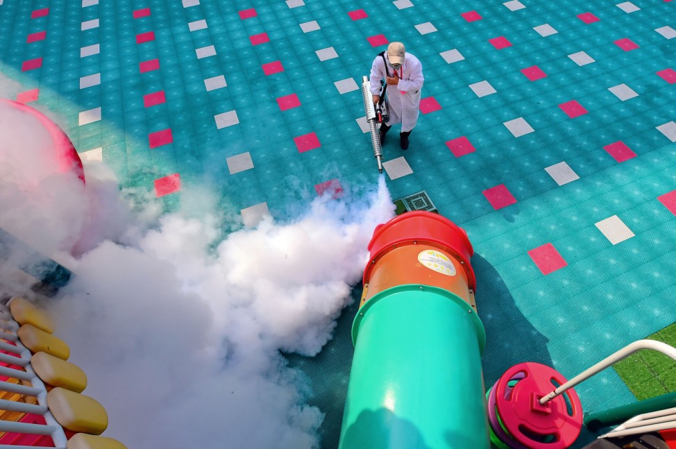 Worker disinfects playground equipment inside a kindergarten as students' returning has been delayed due to the novel coronavirus outbreak, in Ganzhou, Jiangxi