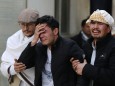 Afghan men cry at a hospital after they heard that their relative was killed during an attack in Kabul, Afghanistan