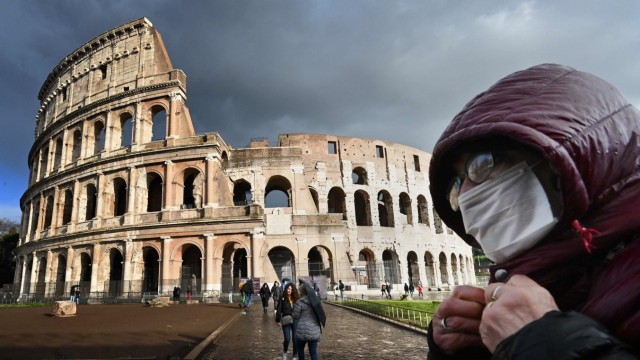 "Sicherheitszone": Obwohl Mediziner von Schutzmasken abraten, gehören sie bei vielen Touristen in Italien – hier am Kolosseum in Rom – derzeit zur Standardausrüstung.