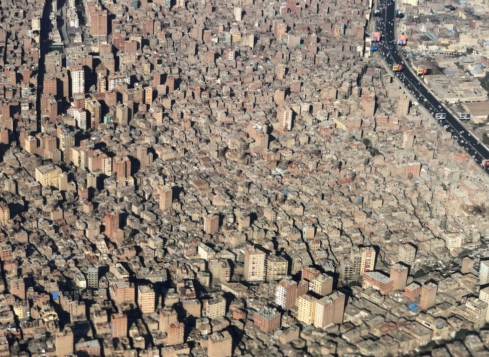 A view from an airplane window shows buildings in an area of dense population in Cairo