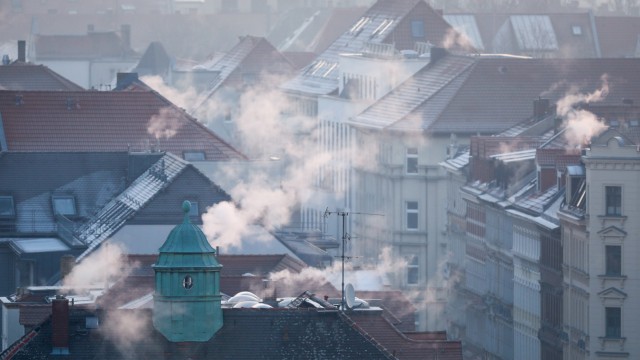 Treibhausgase und CO2: Rauch steigt aus Wohnhäusern auf