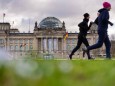 March 21, 2020: Two joggers pass the empty Platz der Republik in front of the German Reichstag. The Governing Mayor of B