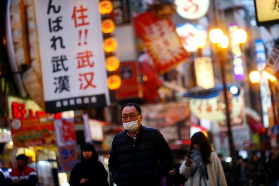 A man, wearing protective mask following an outbreak of the coronavirus disease (COVID-19), walks on an almost empty street in the Dotonbori entertainment district of Osaka