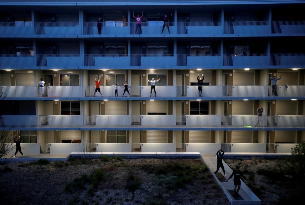 Residents exercise on their balconies following fitness trainers in Nantes