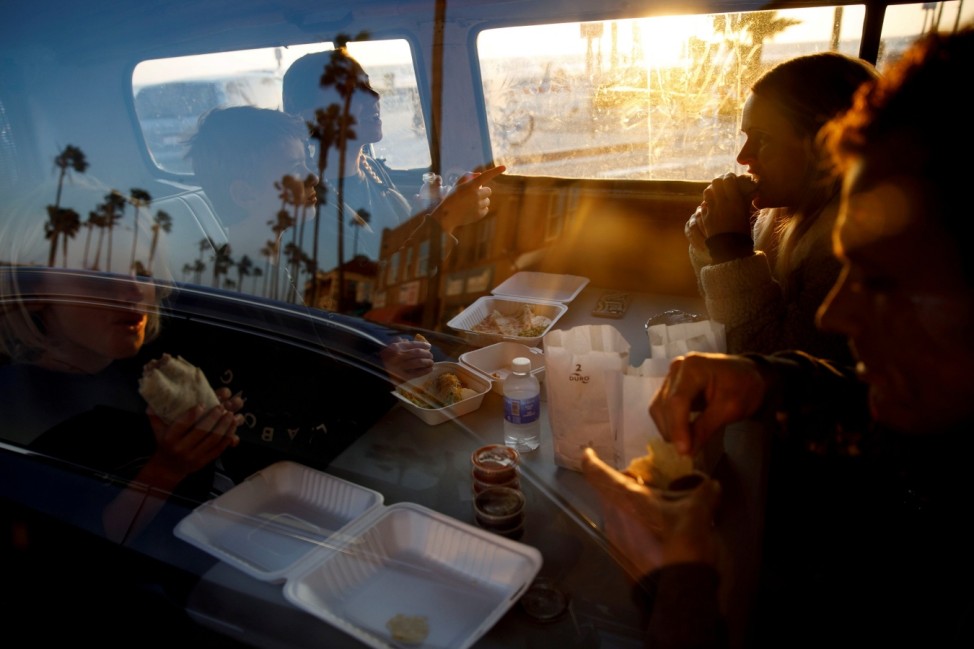 The Stubbs family eats a take-out dinner inside a Volkswagen Bus as authorities encourage social distancing to prevent the spread of coronavirus disease (COVID-19) in Newport Beach, California