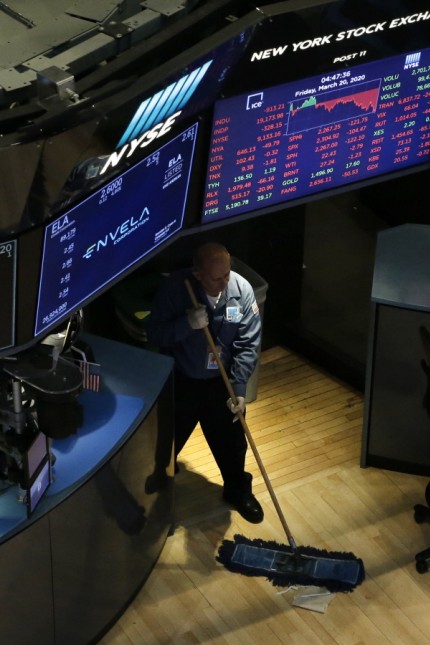 A worker sweeps the floor of the New York Stock Exchange after the closing bell on Wall Street in New York City on Frida