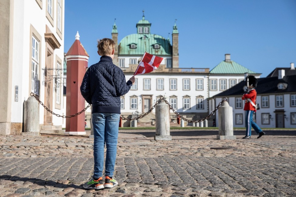 A boy waves a Denmark flag outside Fredensborg Castle, as Danish Queen Margrethe celebrates her 80th birthday, in Fredensborg