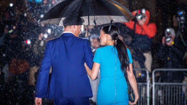 Britische Royals: Royals im Regen: Harry und Meghan haben dem Königshaus den Rücken gekehrt und sich aus der ersten Reihe verabschiedet.