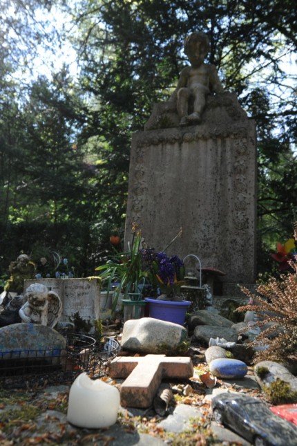 Hadern: Zeichen der Trauer nach dem großen Verlust: Ein Kind wacht über der Grabanlage für Föten und totgeborene Kinder im Waldfriedhof.