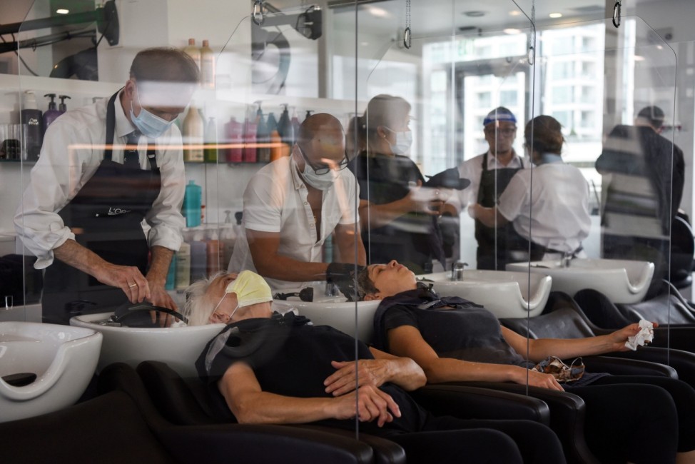 Women are separated by dividers as they have their hair washed after social distancing guidelines to curb the spread of the coronavirus disease (COVID-19) are relaxed, at Bella Rinova in Houston