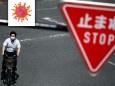 A man wearing a protective face mask is seen under a traffic sign as the spread of the coronavirus disease (COVID-19) continues in Tokyo, Japan