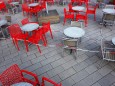 Leere rote Stühle und leere Tische vor einem Cafe - Cafe ohne Besucher - Eisdiele ohne Besucher - Corona-Krise - Virus -