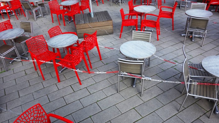 Leere rote Stühle und leere Tische vor einem Cafe - Cafe ohne Besucher - Eisdiele ohne Besucher - Corona-Krise - Virus -