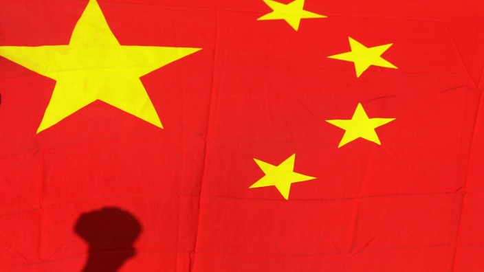 Shadow of clenched fist of protester is seen on Chinese national flag during anti-Japan protest in Beijing
