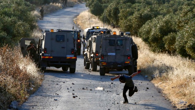 Nahostkonflikt: Ein Palästinenser flüchtet, nachdem er bei Zusammenstößen im Westjordanland am Donnerstag Steine auf Israels Soldaten geworfen hat.
