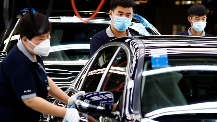 FILE PHOTO: Employees wearing face masks work at a plant of Daimler-BAIC joint ventureâÄÖs Beijing Benz Automotive Co during a government organised tour of the facility following the outbreak of the coronavirus disease (COVID-19), in Beijing
