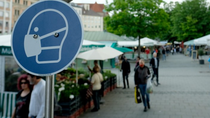 Coronavirus in München: Auf dem Münchner Viktualienmarkt weist ein Schild darauf hin, dass Besucher ihren Mund und ihre Nase bedecken sollen.