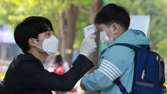 (200527) -- SEOUL, May 27, 2020 (Xinhua) -- A student gets body temperature measured when returning for classes at Seryu